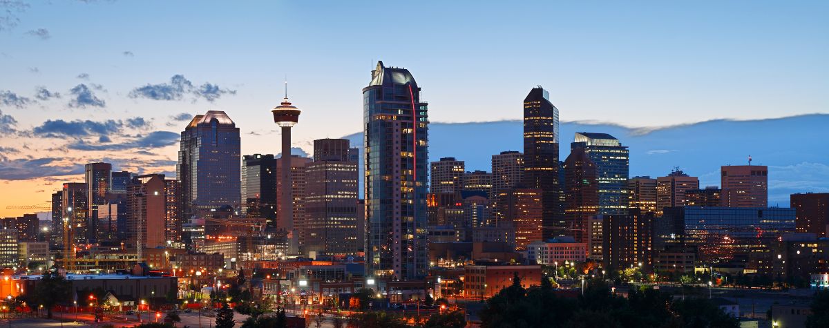 A landscape image of the urban Calgary skyline at dusk